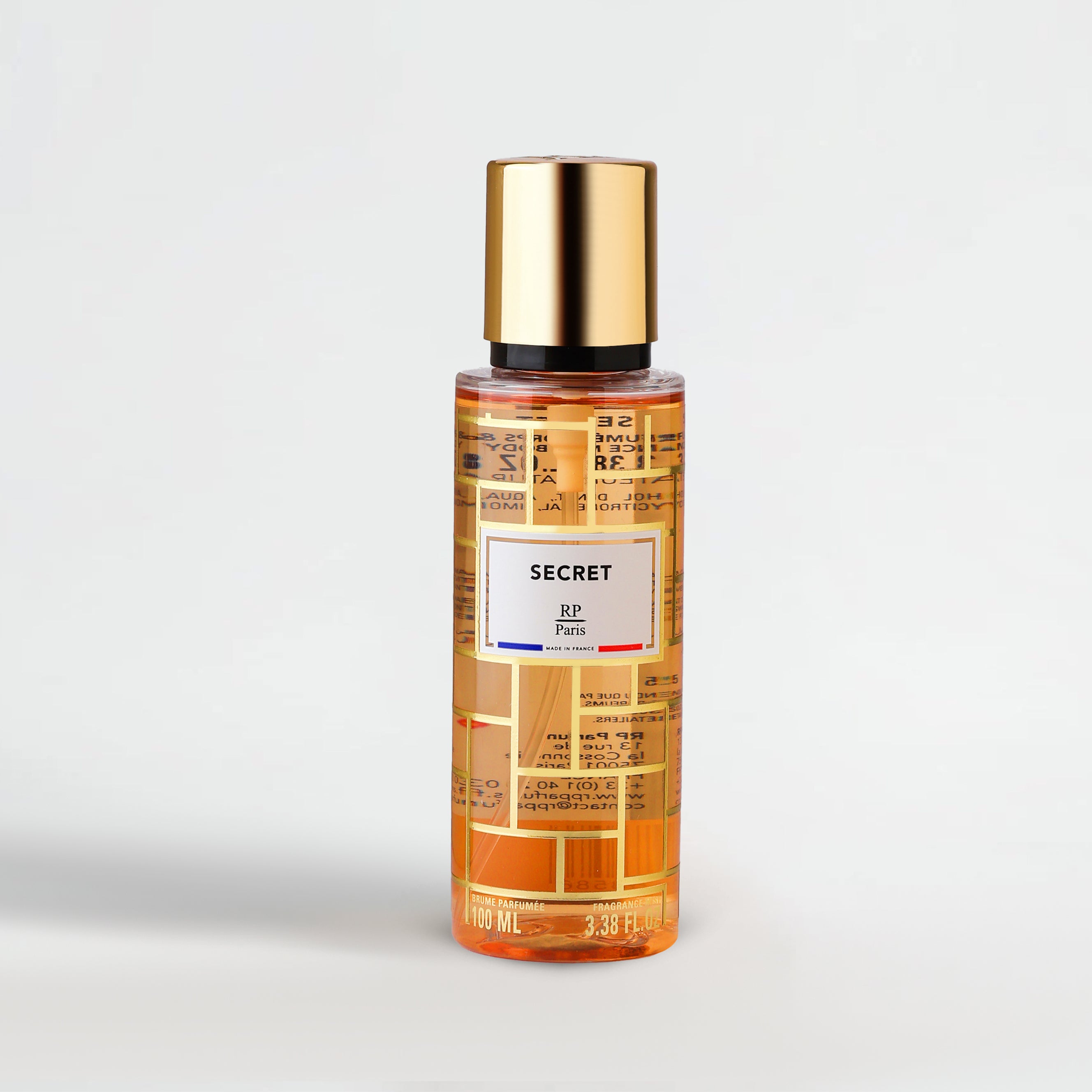 Perfume bottle with gold cap and label on a light gray background