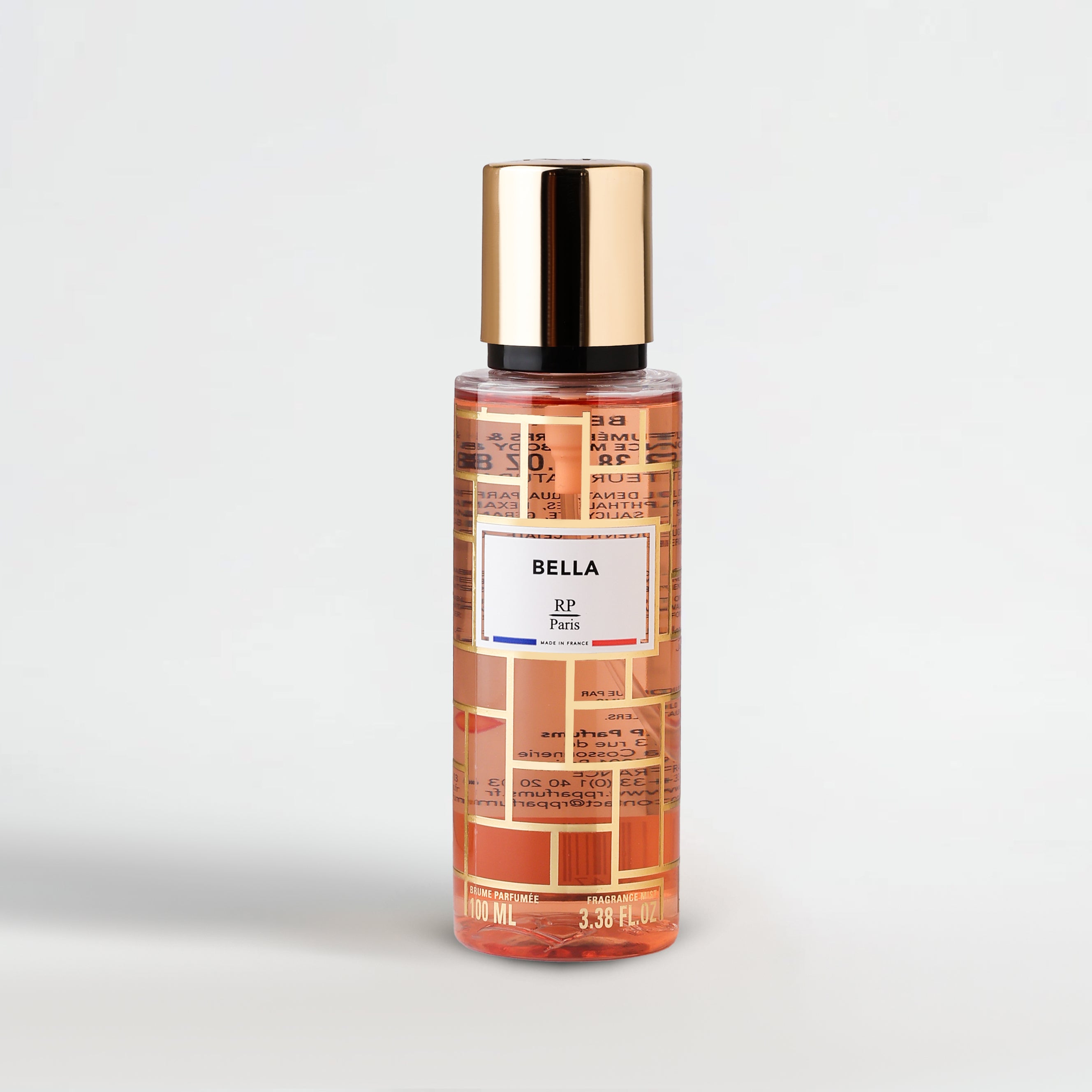 Perfume bottle with gold cap and patterned label on a light gray background