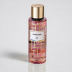 Perfume bottle labeled 'Paradise' with gold cap on a light gray background