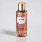 Perfume bottle with gold cap and pink label on a light gray background