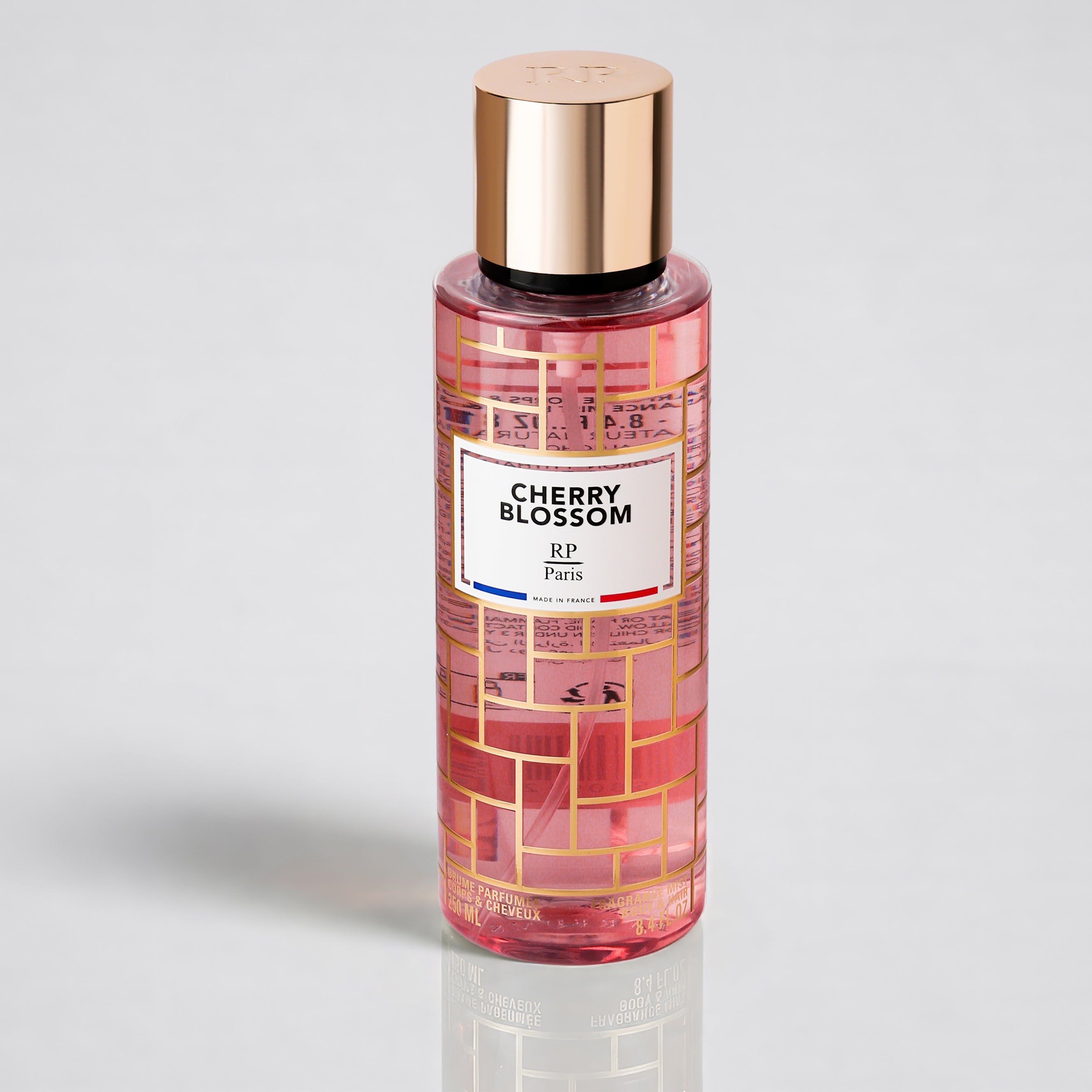 Perfume bottle labeled 'Cherry Blossom' with a gold cap on a light gray background