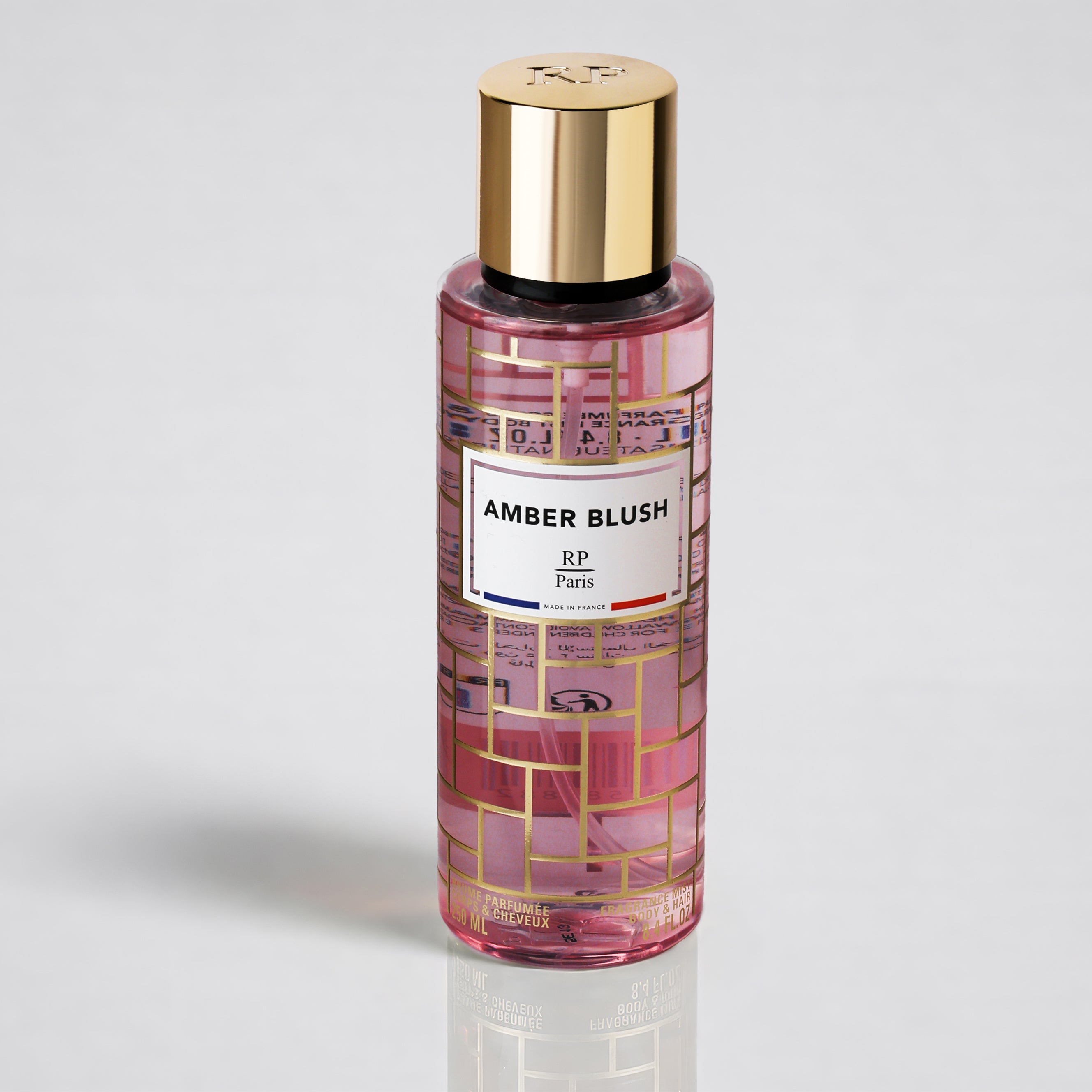 Perfume bottle labeled 'Amber Blush' with gold cap on a light gray background
