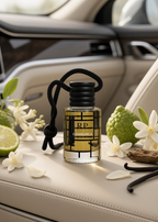 A clear glass perfume bottle with a black cap and black hanging cord sits on a beige leather car seat, surrounded by white flowers, a lime half, a green bumpy fruit, and dark vanilla beans. The bottle label reads RP and CASALANICA.
