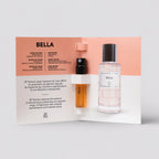 Bella perfume bottle and smaller sample in a display box on a light gray background