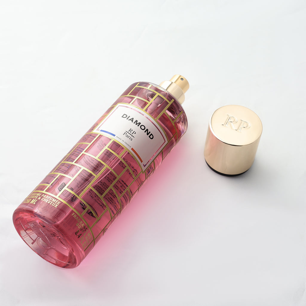 Pink and gold bottle with a cap on a light gray background