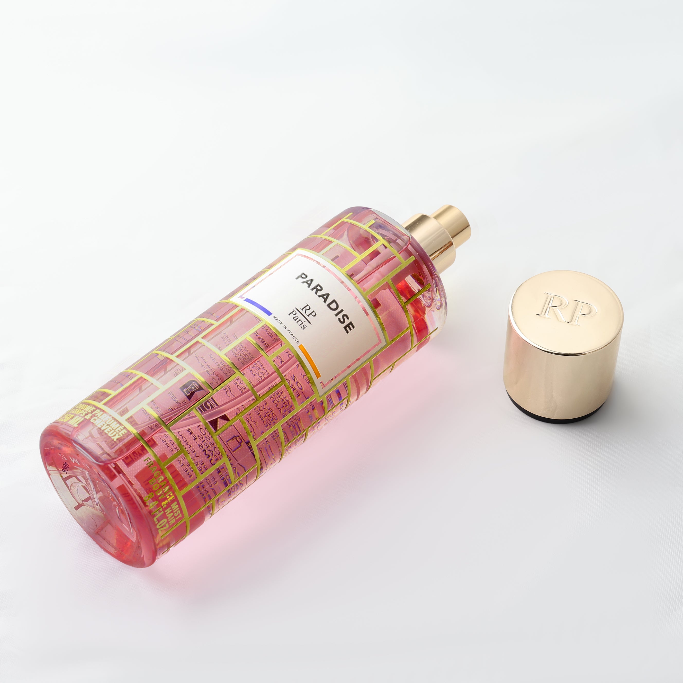 Perfume bottle with gold cap on a light gray background