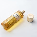 Perfume bottle labeled 'Oud Mood' with a gold cap on a light background