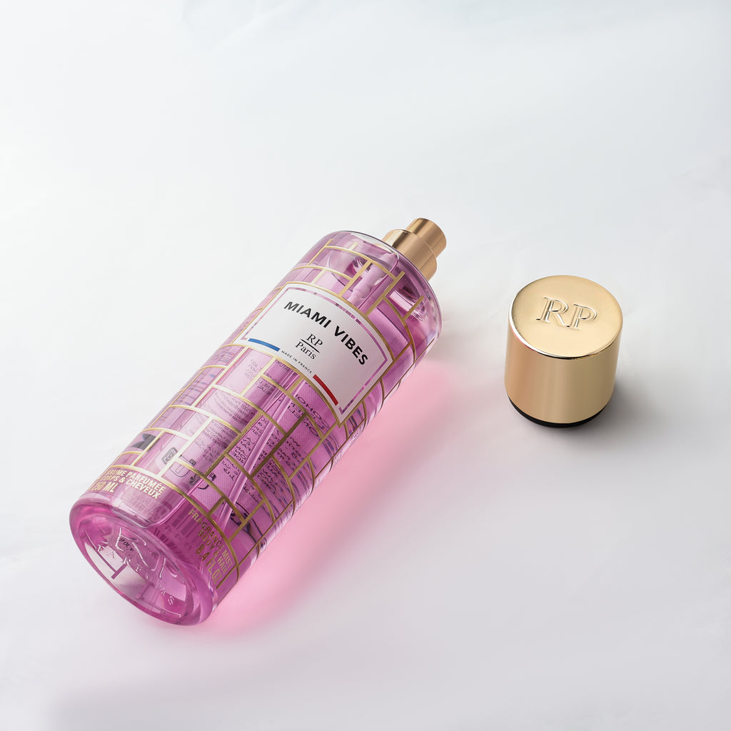 Pink perfume bottle with gold cap on a light gray background
