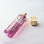 Pink perfume bottle with gold cap on a light gray background