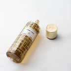 Gold perfume bottle with cap on a white background