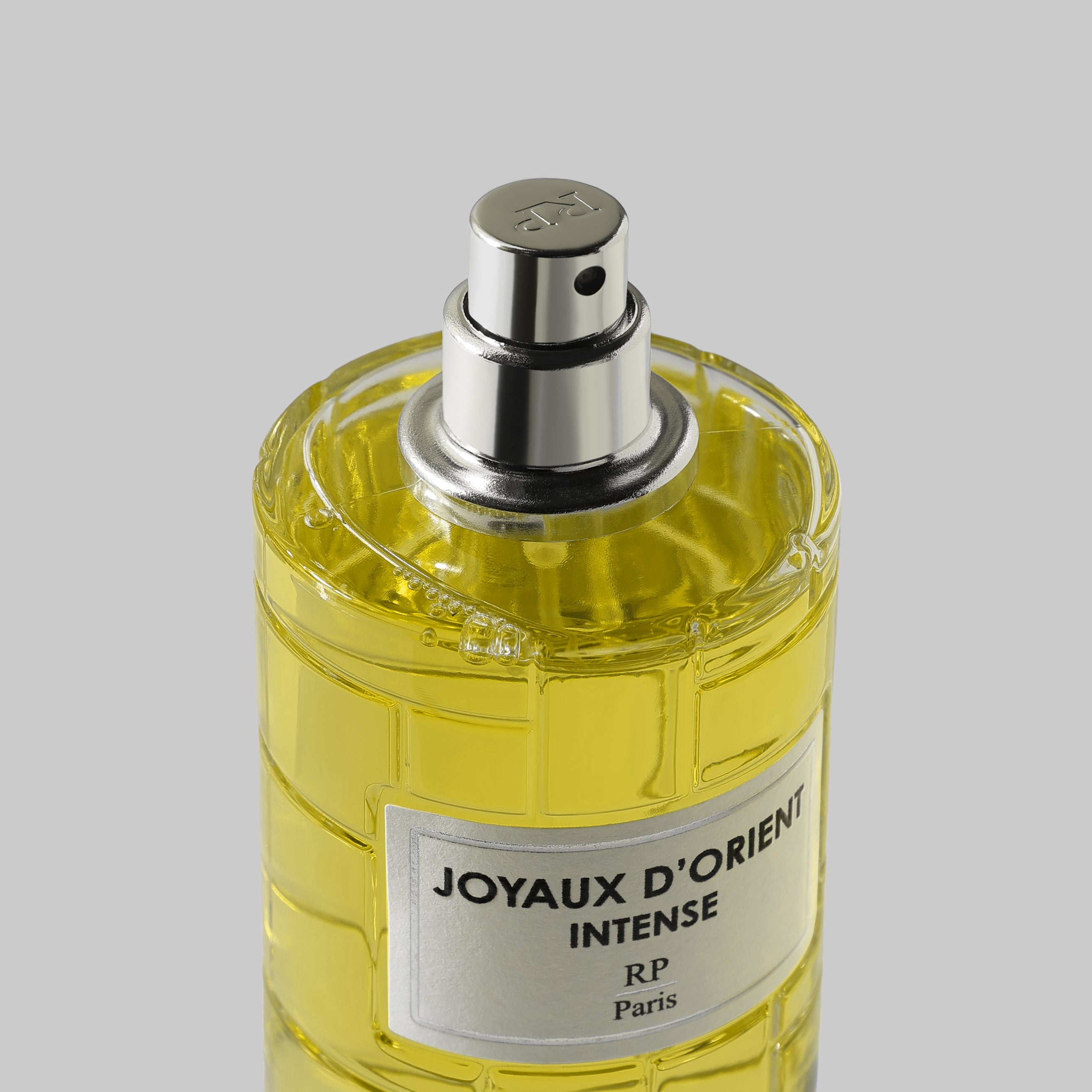 Perfume bottle labeled 'Joyaux d'Orient Intense' by RP Paris on a gray background