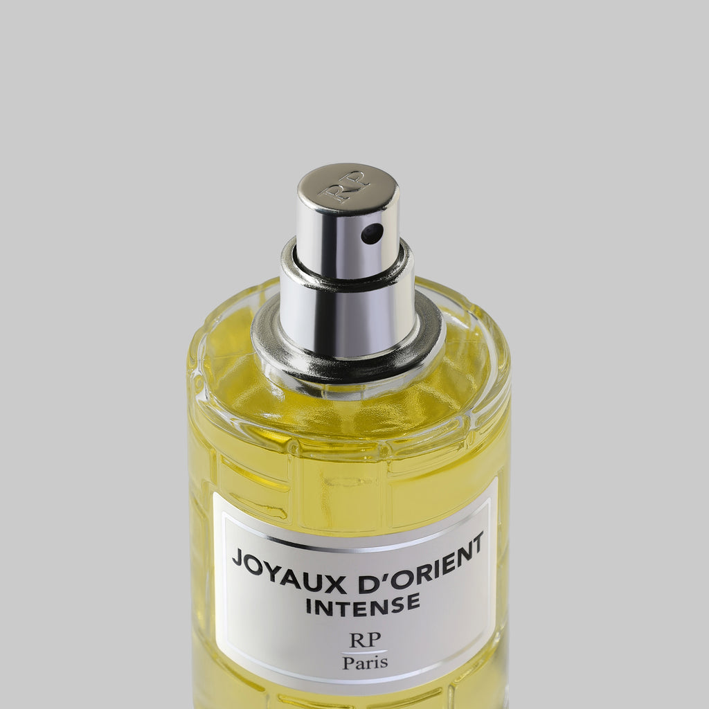 Perfume bottle labeled 'Joyaux d'Orient Intense' on a gray background