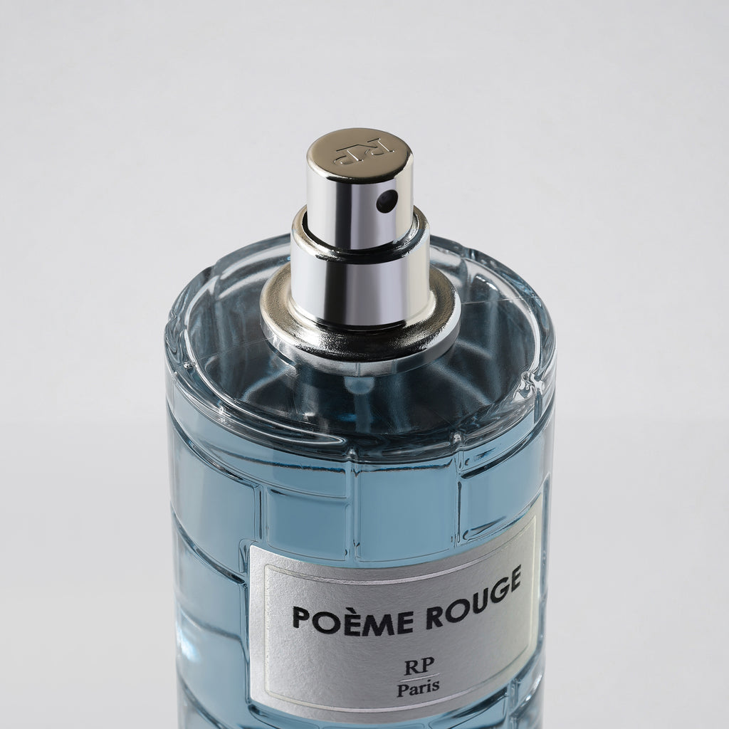 Perfume bottle labeled 'Poème Rouge' with a silver cap on a light gray background