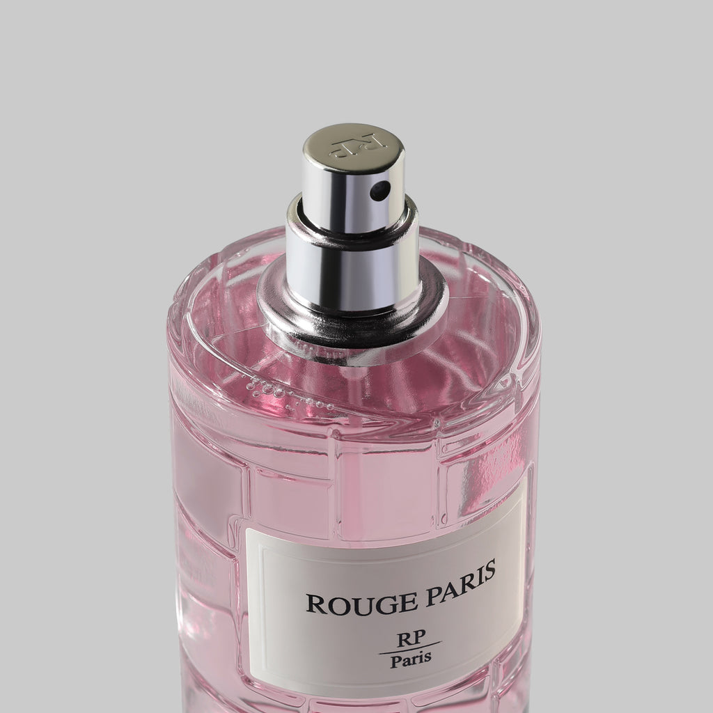 Pink perfume bottle with silver cap on a light gray background