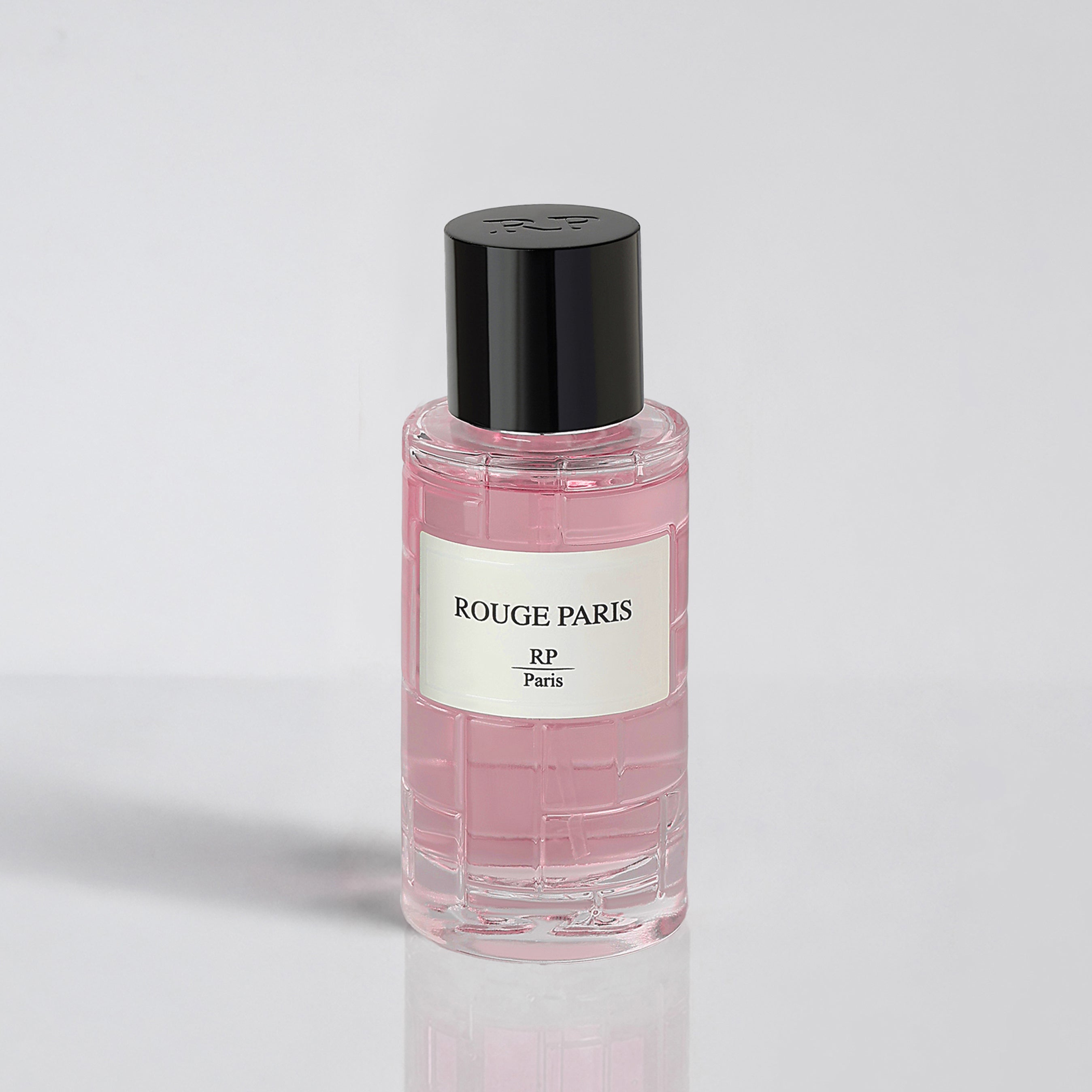 Pink perfume bottle with black cap and 'Rouge Paris' label on a light gray background