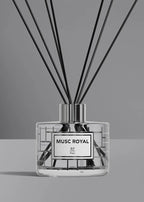 A reed diffuser bottle with a clear glass body, black reeds, and a silver cap, featuring a white label with black text that reads 'MUSC ROYAL JP Paris'.