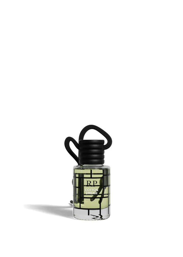 A small clear glass bottle with a black cap and black hanging loop, containing pale yellow-green liquid, shown on a plain white background. The bottle has a black geometric grid label with the letters RP and text that appears to read 'Raspberry Bay' and 'Scented Oil'.