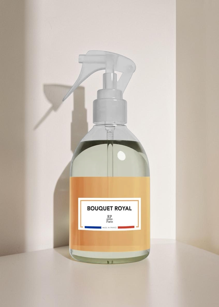Clear spray bottle with a yellow label on a white background