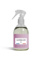 A clear plastic spray bottle filled with pale yellow liquid, featuring a lavender pink label with 'CALIFORNIA LOVE' and 'R.F.