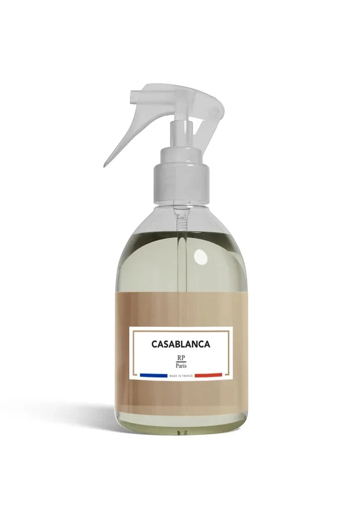 Clear spray bottle with a beige label on a white background