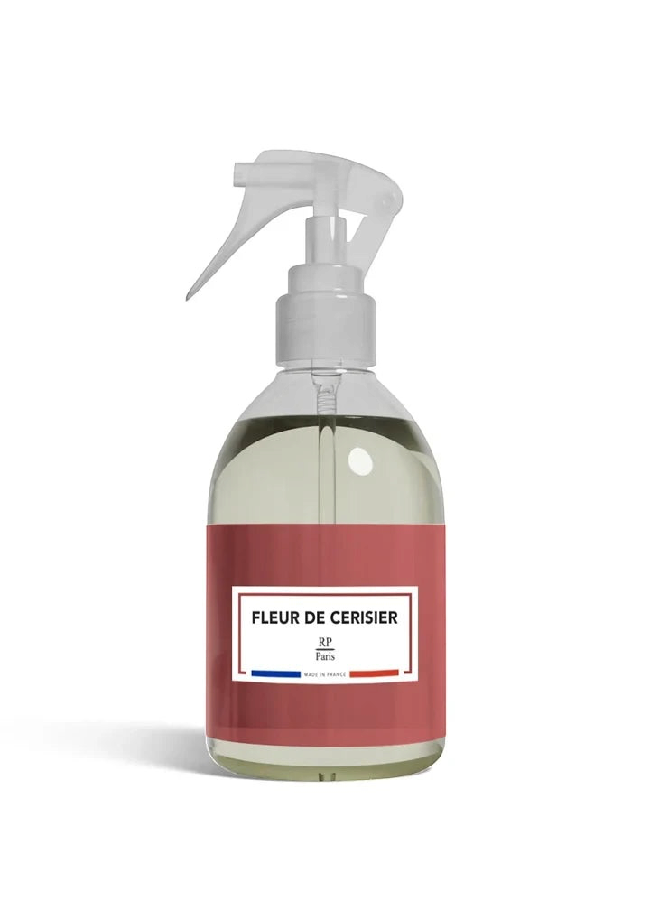 Clear spray bottle with a red label on a white background