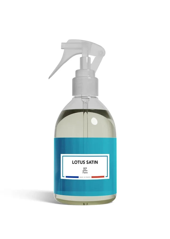 A clear plastic spray bottle filled with a pale yellow liquid, featuring a white trigger sprayer and a bright blue label with the text 'LOTUS SATIN' and 'BY Paris'.