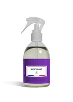 A clear plastic spray bottle filled with a pale yellow liquid, featuring a prominent purple label with a white label that reads 'MUSC BLANC' and 'BF Paris'.