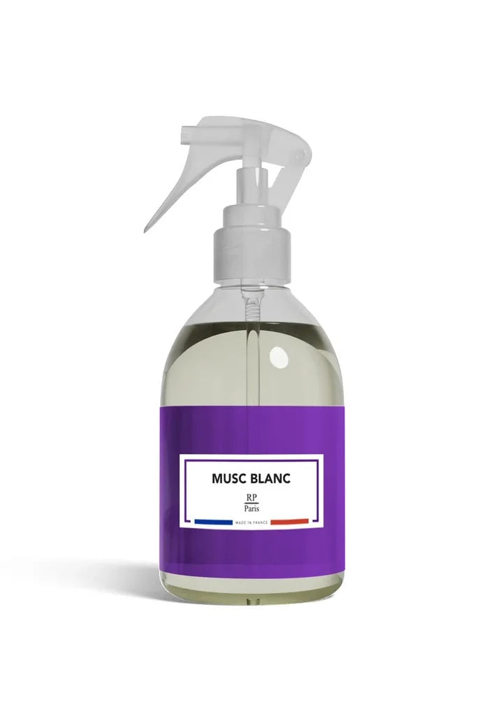 A clear plastic spray bottle filled with a pale yellow liquid, featuring a prominent purple label with a white label that reads 'MUSC BLANC' and 'BF Paris'.