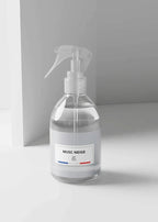 A clear glass spray bottle with a white trigger sprayer and a white label reading 'MUSC NEIGE' on a minimalist light gray background.