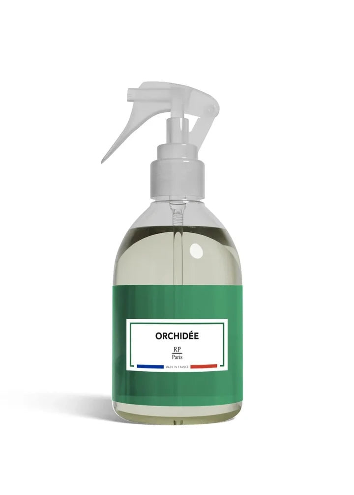 Clear spray bottle with green label on a white background