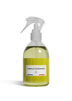 A clear spray bottle filled with pale yellow-green liquid, featuring a white trigger sprayer and a white label that reads 'VANILLE ÉLÉGANTE' with '80 VPM' below, set against a plain white background.