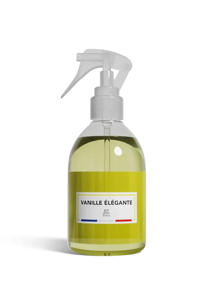 A clear spray bottle filled with pale yellow-green liquid, featuring a white trigger sprayer and a white label that reads 'VANILLE ÉLÉGANTE' with '80 VPM' below, set against a plain white background.