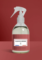 Clear spray bottle with a red label on a red background fleur de cerisier