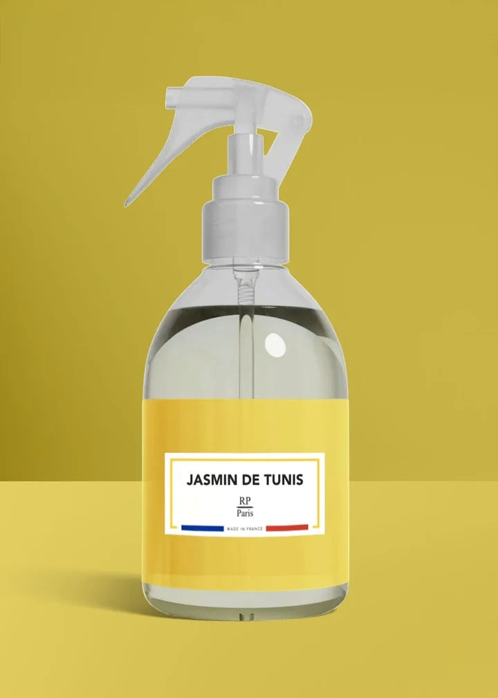 Clear spray bottle with a yellow label on a mustard yellow background