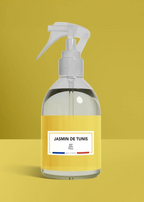 Clear spray bottle with a yellow label on a mustard yellow background