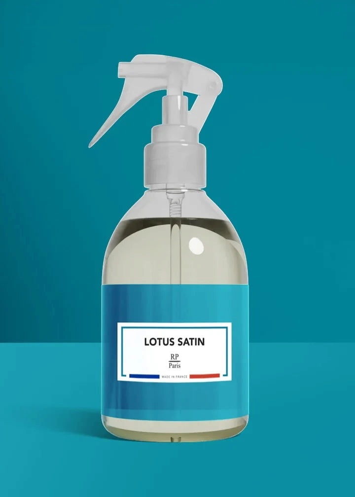 Clear spray bottle with white nozzle on a blue background