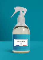 Clear spray bottle with white nozzle on a blue background