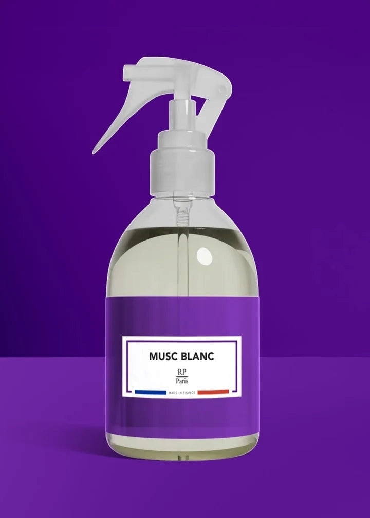 Clear spray bottle with a purple label on a purple background