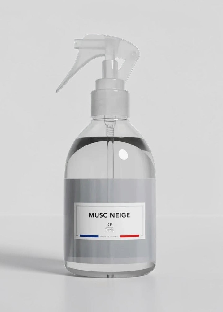 Clear spray bottle with a label on a gray background