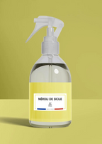 Clear spray bottle with a yellow label on a green background