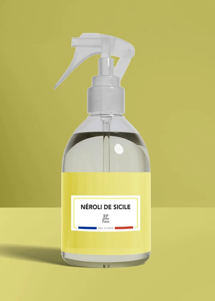 Clear spray bottle with a yellow label on a green background