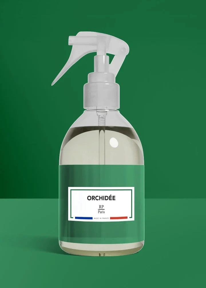 Clear spray bottle with a green label on a green background