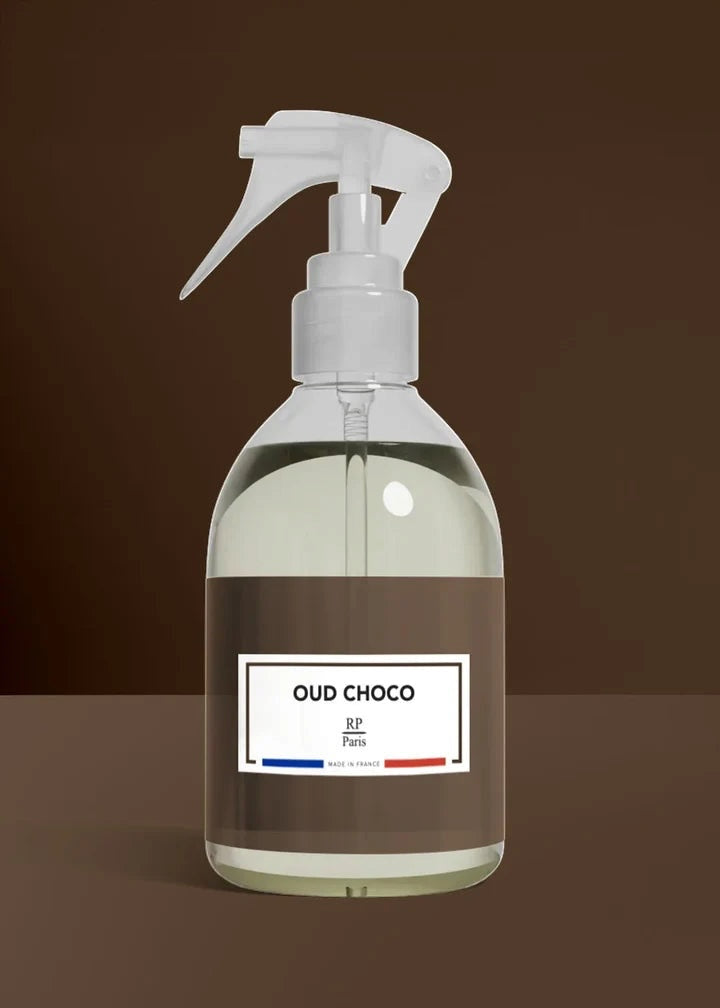 Clear spray bottle with a label on a brown background