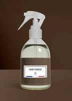 Clear spray bottle with a label on a brown background